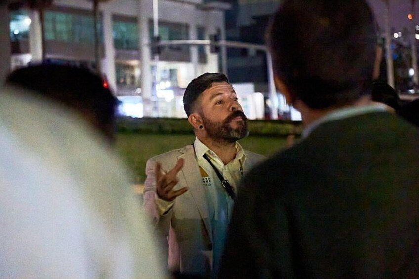 A person in a suit gesturing while talking to another person. 1