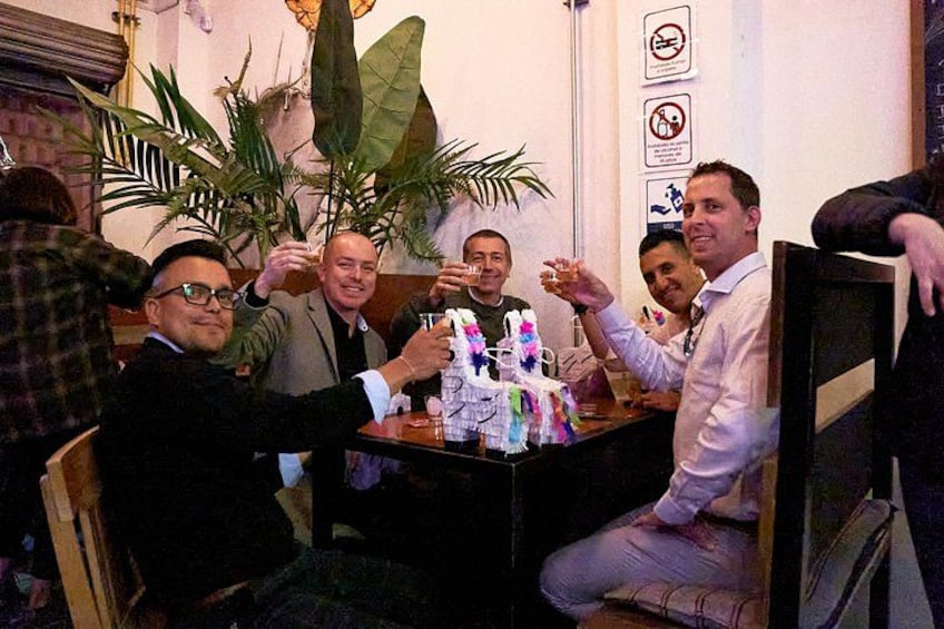 A group of people toasting around a table with a cake. 4