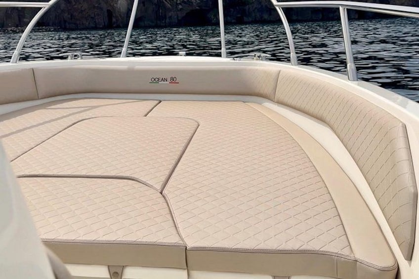 A boat's interior with a cushioned seating area and a brand name 'OCEAN 80' on the side. 3