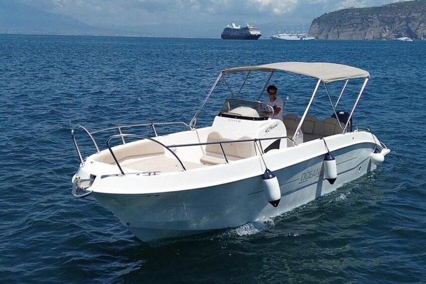 A white motorboat with a canopy on the water. 4