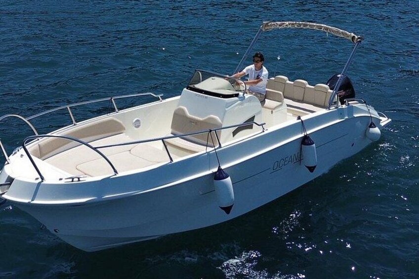 A white motorboat with a canopy on the water. 3
