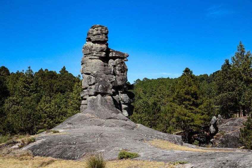 A large rock formation with a prominent vertical stack of stones. 1