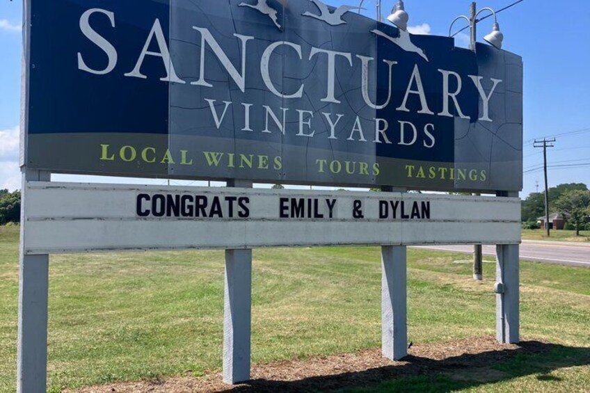 A sign for Sanctuary Vineyards advertising local wines, tours, and tastings. 4