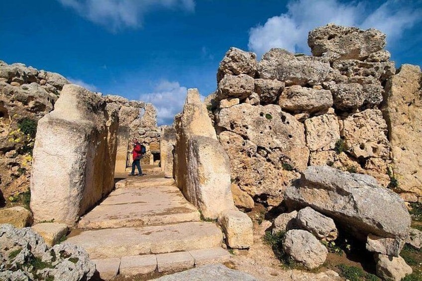 Ancient ruins with stone pathways and a person in red. 2
