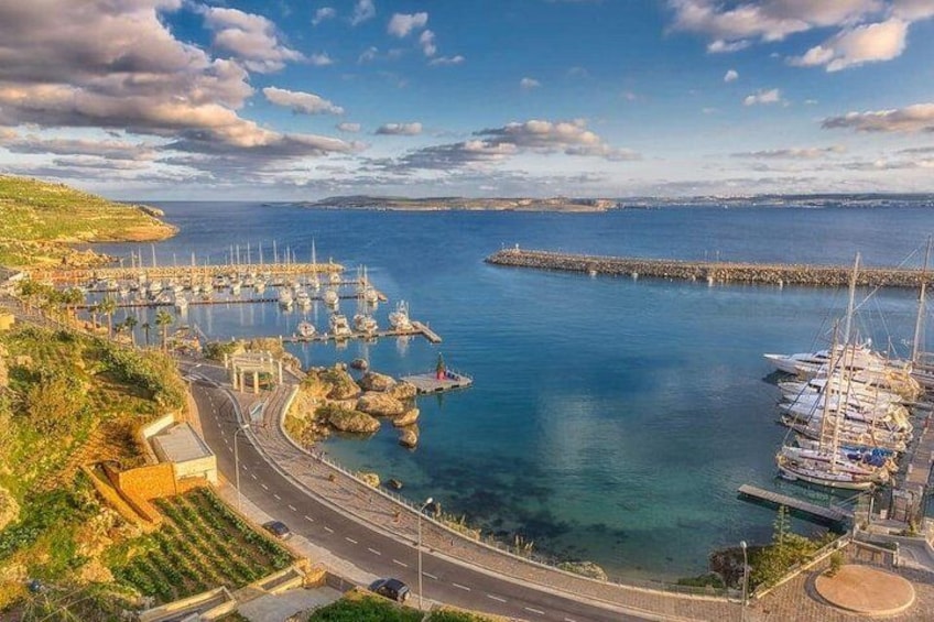 A coastal marina with boats, a pier, and a road leading to the marina. 3
