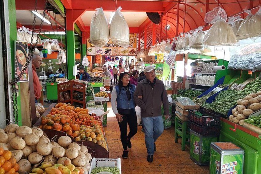 Un marché couvert animé où l’on peut trouver une grande variété de fruits et de légumes. 2