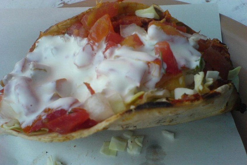 Una pizza a metà, condita, su una superficie bianca. 4
