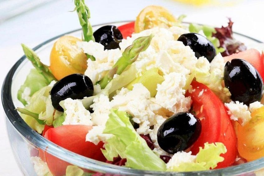 Ein Salat mit Blattsalat, Tomaten, schwarzen Oliven und Feta-Käse. 5