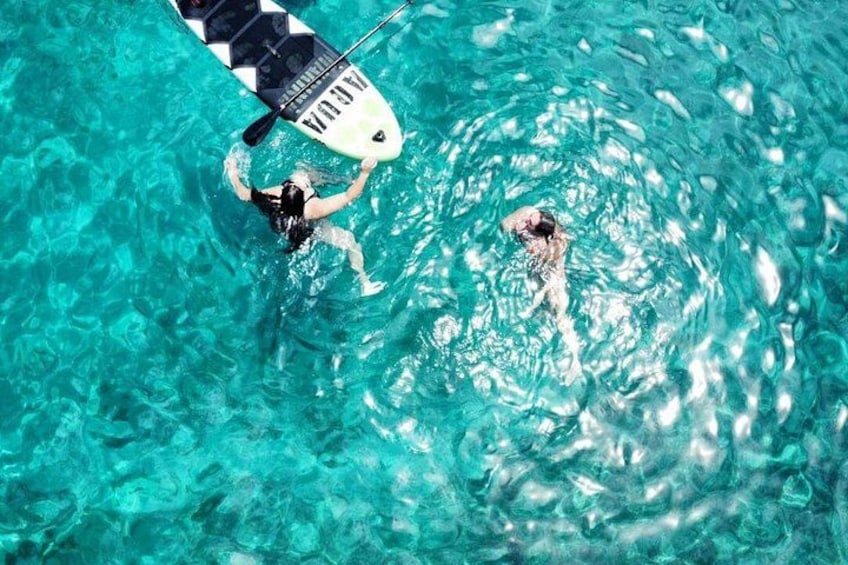 Eine Person schwimmt in einem Pool mit einem Stand-Up-Paddleboard. 2