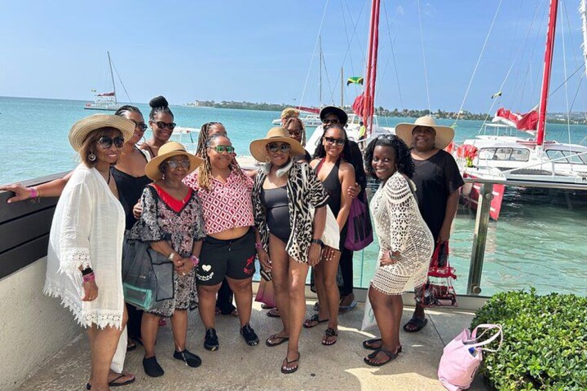 A group of people standing by a dock with boats in the background. 3