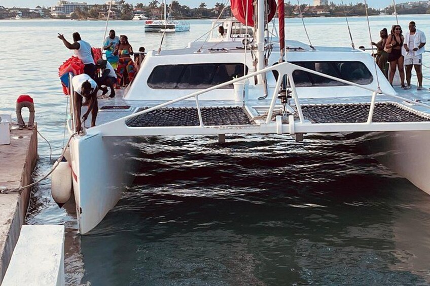 A white boat docked at a pier with people boarding and disembarking. 3