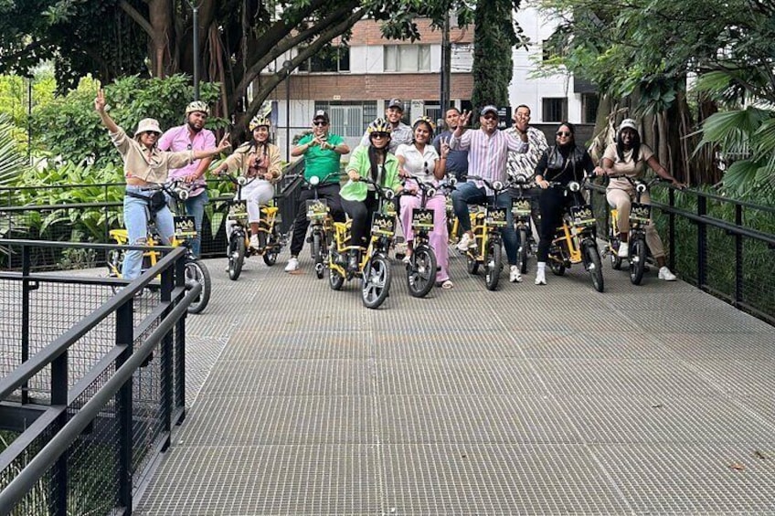 A group of people on bicycles on a bridge with greenery around. 4