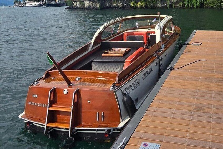 A wooden boat docked at a pier with a name 'BROOKLYN BOAT TOURS' on its side. 1
