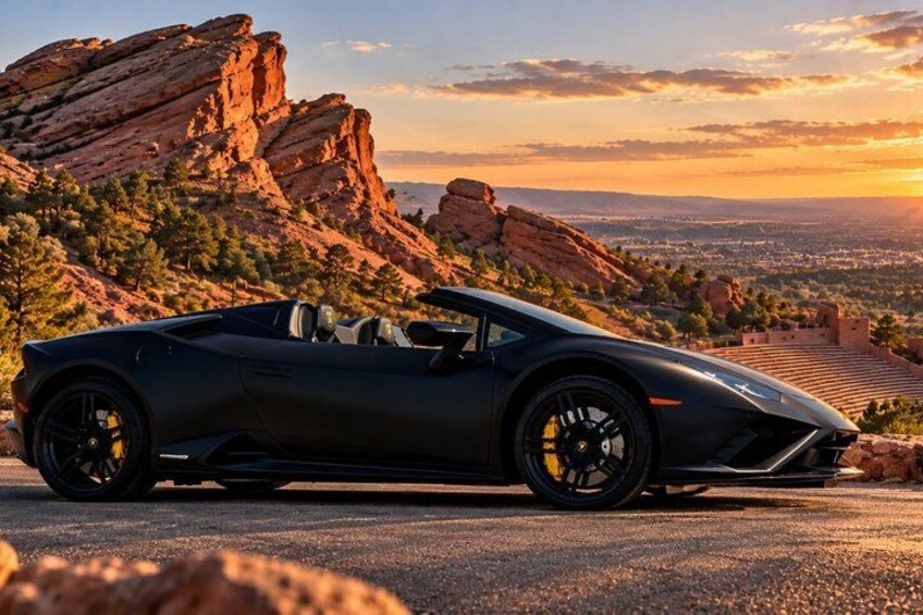 A black convertible sports car parked on a road with a mountainous landscape in the background. 4