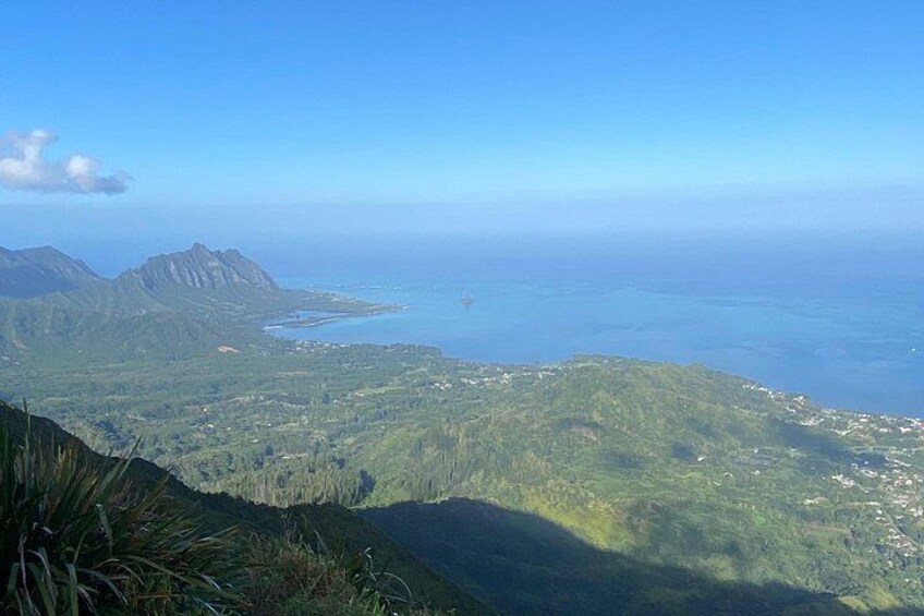 A coastal landscape with mountains, a clear sky, and a view of the ocean. 2