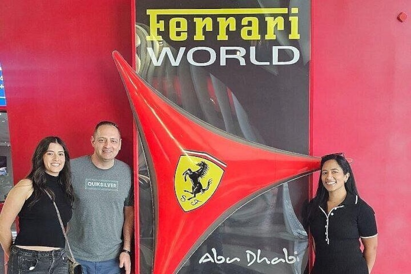 Una bandera roja de Ferrari con el logotipo de Ferrari y el texto 'Ferrari World' y 'Abu Dhabi' sobre un fondo rojo. 5