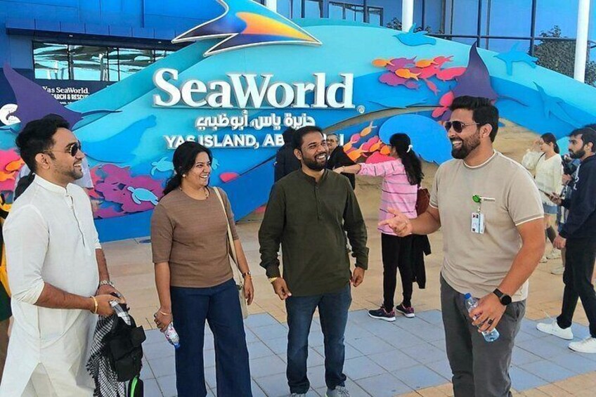 Un groupe de personnes se tient devant une enseigne colorée de SeaWorld. 2