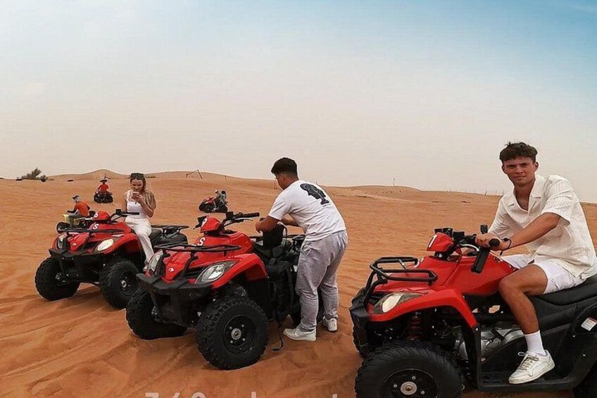People on red ATVs in a desert. 5
