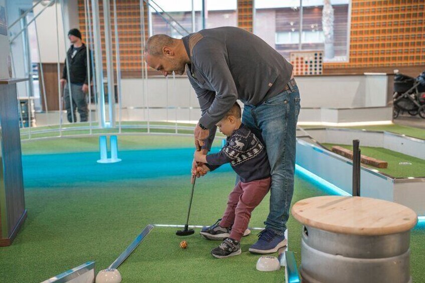 A man and a child playing mini-golf. 2