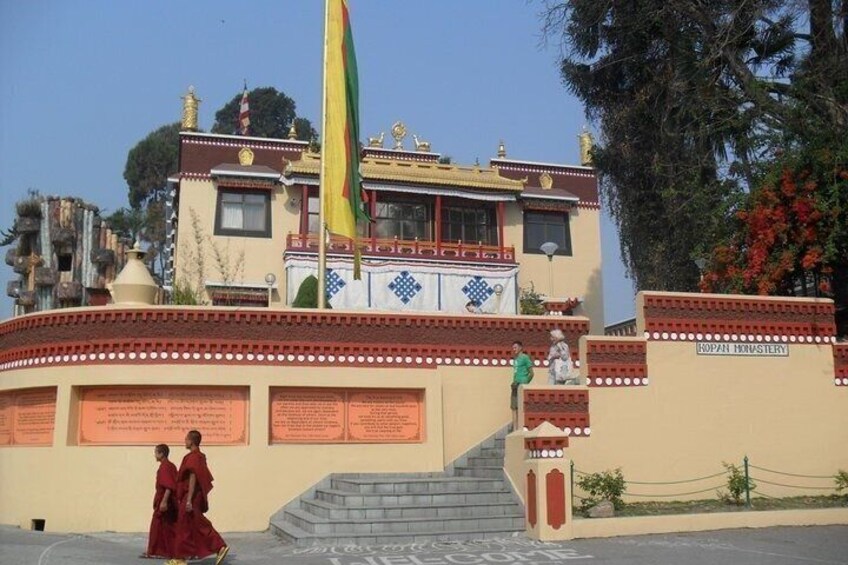 A traditional building with a flag, a staircase, and informational plaques. 2