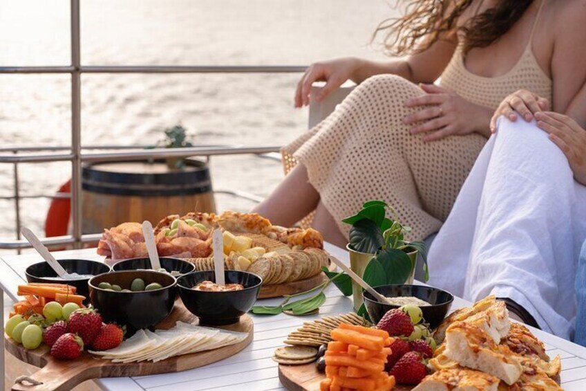 A picnic setup with food and drinks on a boat. 1
