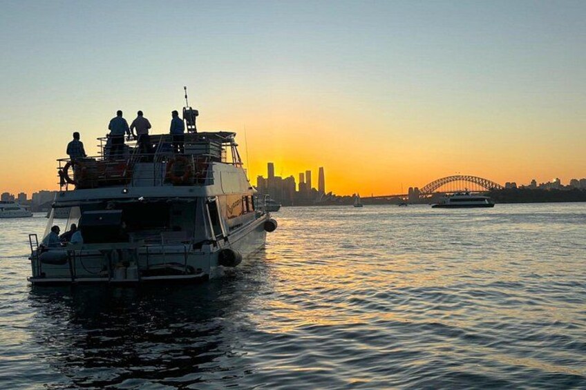 Een veerboot met passagiers bij zonsondergang, met de Opera van Sydney en de Harbour Bridge op de achtergrond. 3