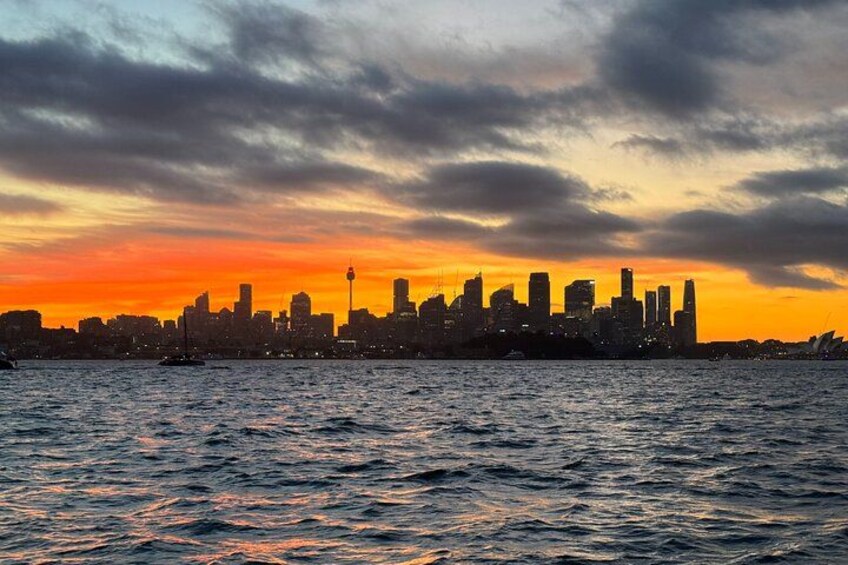 Byens skyline i solnedgang med et vandareal i forgrunden. 2