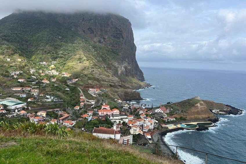 A coastal town with houses, a cliff, and the ocean. 3