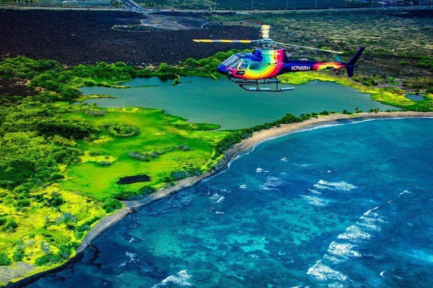 A helicopter over a coastal area with clear blue waters and green vegetation. 2