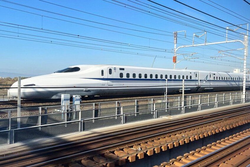 A high-speed train on tracks with overhead electrical lines. 3