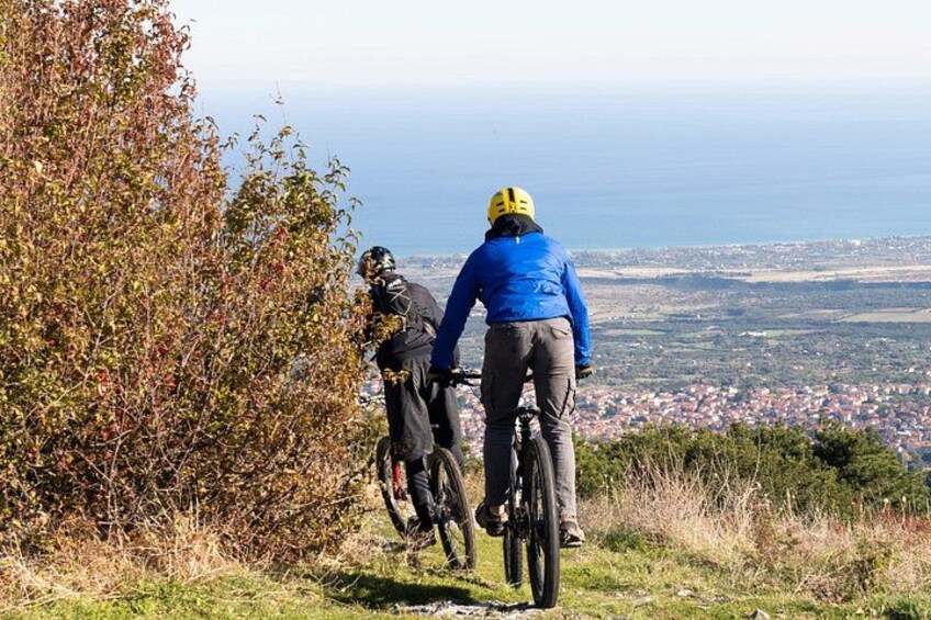 Two cyclists on a trail with a coastal view. 2