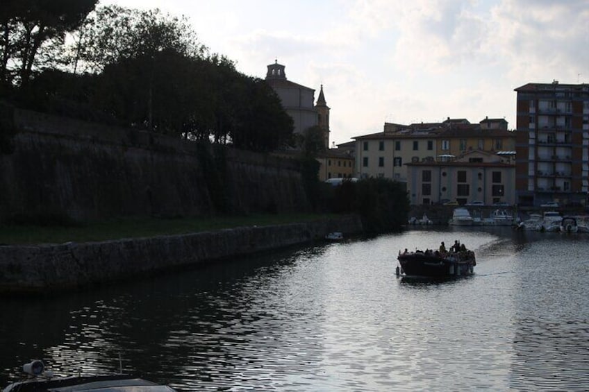 A boat on a river with buildings in the background. 2