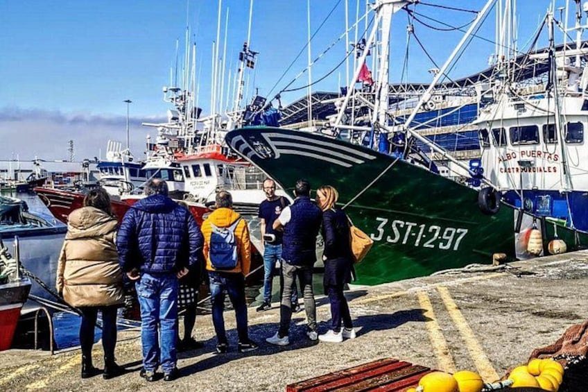 A harbor with boats, people, and a green ship with the number 3ST1297. 1