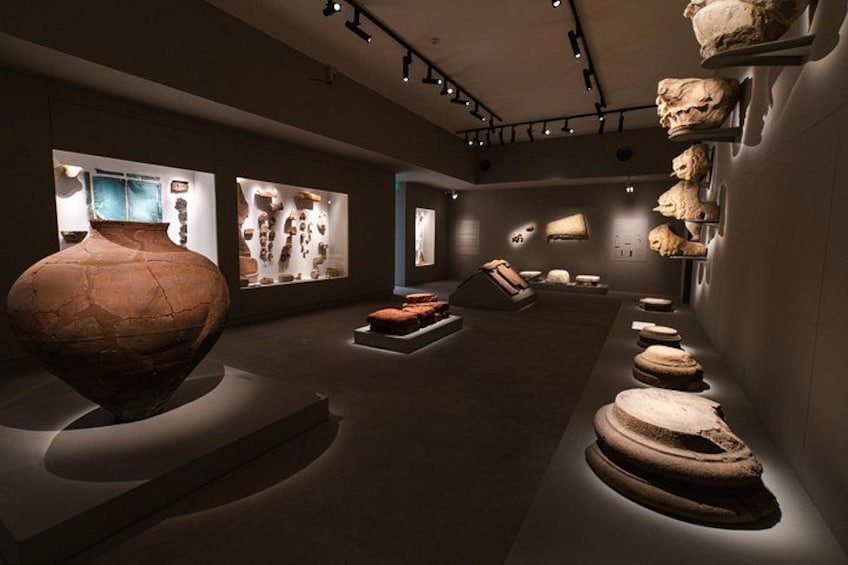 An indoor museum with pottery and sculptures on display. 5