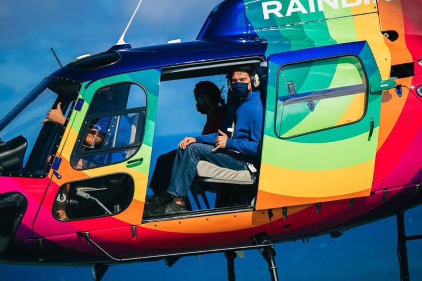 A colorful helicopter with the word 'RAINDROP' on the side, a person sitting inside, and another person standing outside. 3