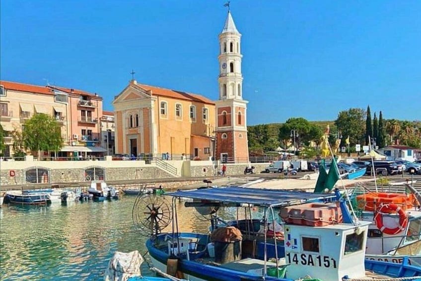 A harbor with boats, a church, and a tower. 3