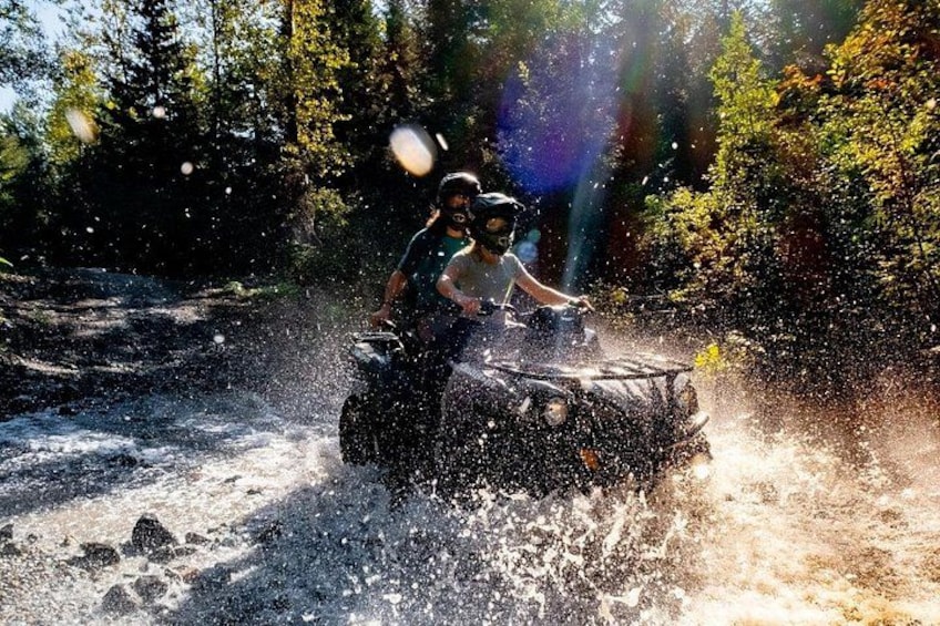 A person riding a watercraft through a river surrounded by trees. 4