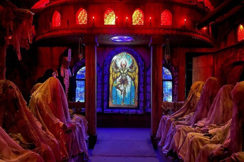 Un interior gótico con vidrieras, bancos de madera y un altar central. 1