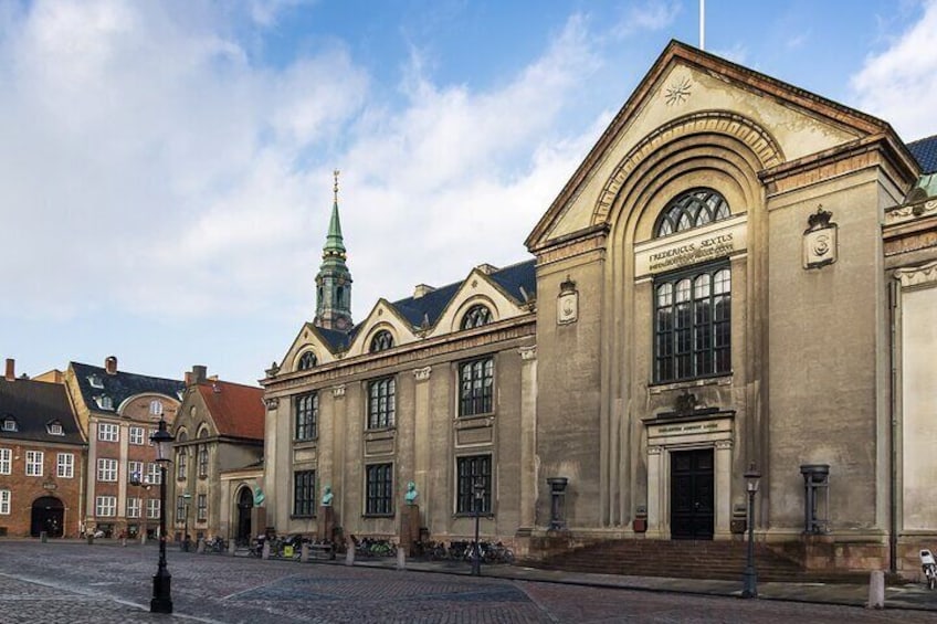 Een historisch gebouw met een opvallende klokkentoren en boogvensters. 5