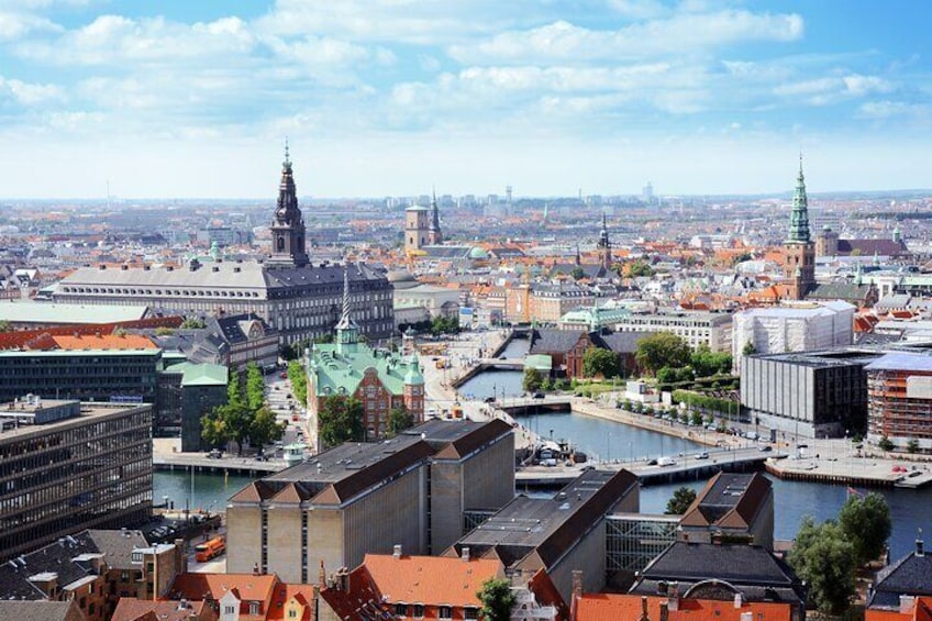 Een stadsgezicht met opvallende historische gebouwen, een rivier en een brug. 2