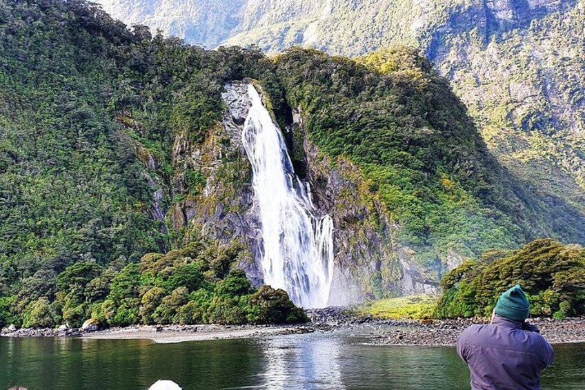 Une cascade d’eau se déversant sur une montagne verdoyante. 4