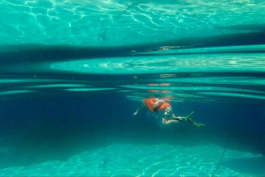 A person swimming underwater in clear blue water. 2