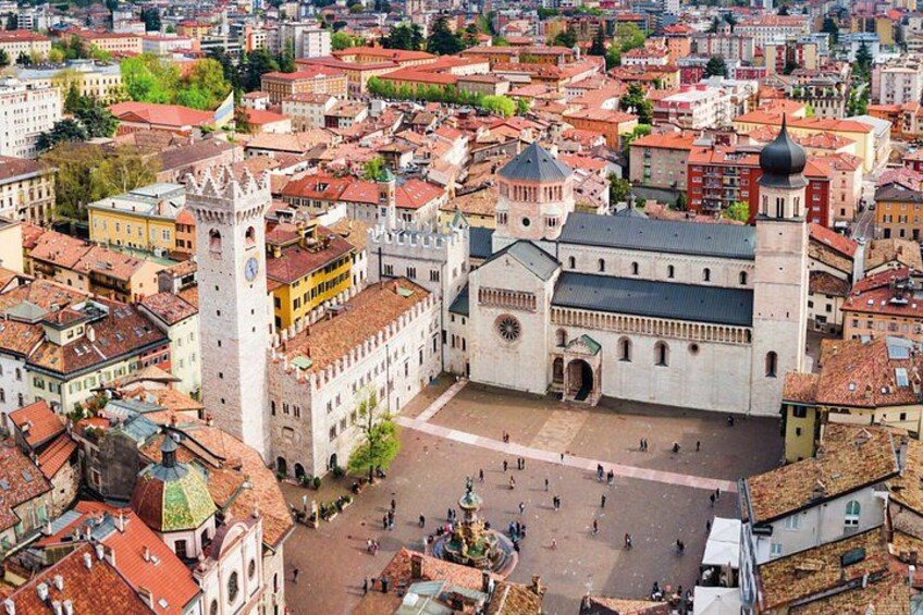 A historic city square with a prominent church and a clock tower. 5