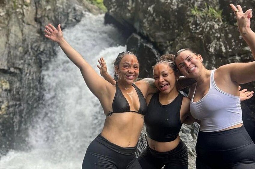 Three people standing in front of a waterfall. 4