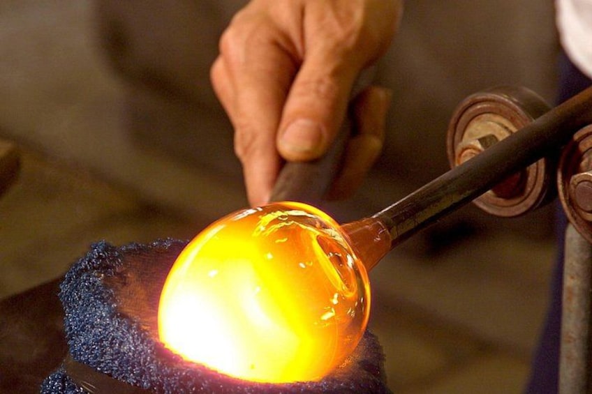 A person working with molten glass on a furnace. 1