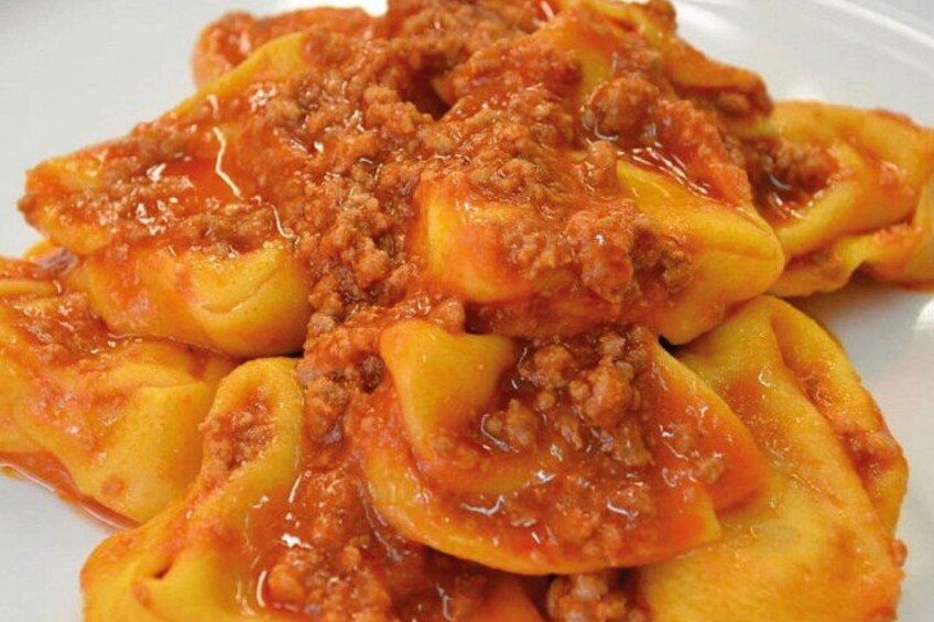 Een bord ravioli met een vleessaus. 5