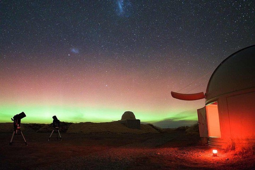 A night sky with stars, a green aurora, a dome structure, and a tent. 4