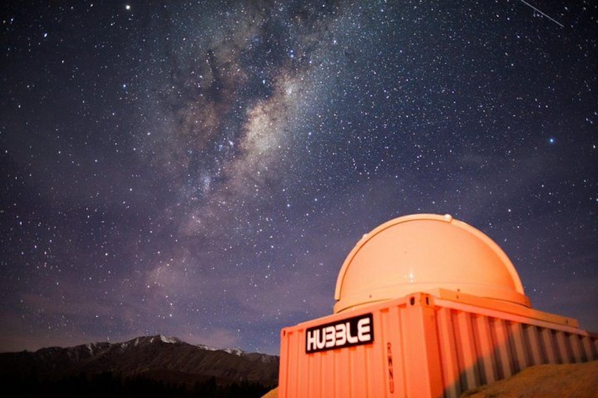 A starry night sky with a dome observatory labeled 'HUBBLE' against a mountainous backdrop. 3