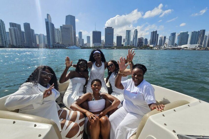 Un grupo de personas en un barco, con un horizonte urbano al fondo. 3