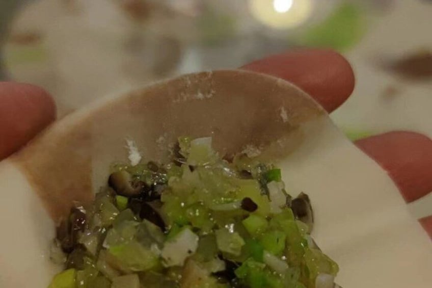 A hand holding a bowl with a green vegetable mixture. 2
